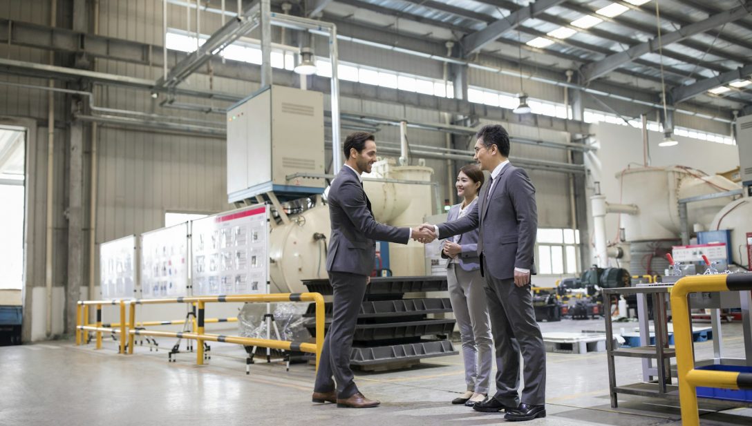 Business people shaking hands in the factory